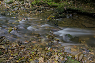 Langzeitbelichtung eines kleinen Wasserfalls im Wald