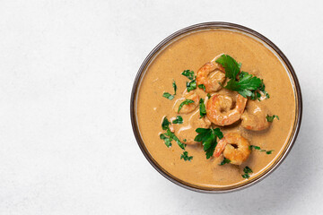 Curry shrimp in white bowl on light background with copy space top view. Asian food concept