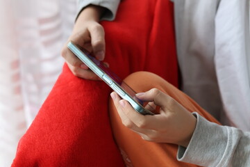 Close up of a boy's hands holding a smartphone and playing a game on the smartphone © Gosia