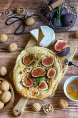 Pie with figs and cheese, as well as nuts and cheese on the table.