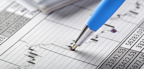 Accounting document with pen, money, coins and checking financial chart. Concept of banking,...