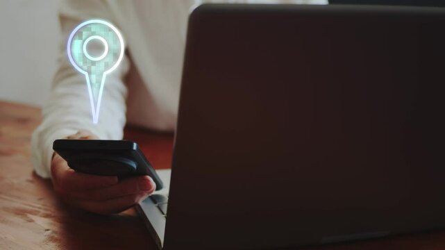 A businessman working on a laptop and with a smartphone demonstrates a hologram of symbolic icons characterizing the digitalization of logistics. Online carrier tracking GPS. Cg