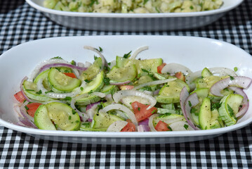 healthy food dish with salad greens vegetables seasoned salad vegan lunch tomato and onion green zucchini