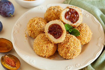 Traditional sweet steamed dumplings with a plum jam, sprinkled with sweet crumble and cinnamon on  plate