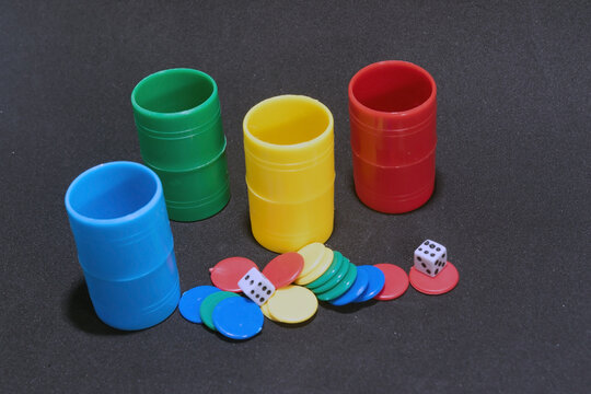 cubos y fichas de parch&iacute;s con dados sobre fondo negro