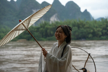Happy Hanfu Woman smiles and thumbs up by Li River. China, 4K