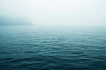 Obraz premium A Silhouette of Land Emerging From a Misty Sea