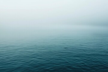 Obraz premium Calm Water Surface Under a Foggy Sky