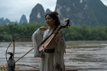 Hanfu girl smiling over Li River puts a pipa traditional instrument in her back