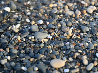 A beach with rocks and pebbles, and small stones up close.