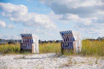 weiß blauer Strandkorb vor Ferienhäusern am Strand