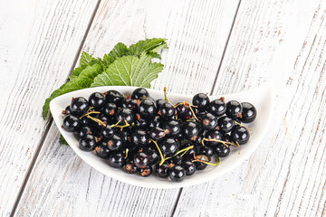Juicy black currant berries in the bowl