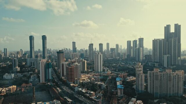 Cinematic aerial view of Mumbai city on a beautiful sunny and cloudy day during the monsoon season in Maharashtra, India.