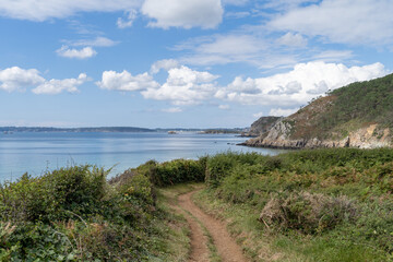 Depuis le sentier c&ocirc;tier, la vue sur la plage de Trez Bihan est saisissante : une vaste &eacute;tendue de sable bord&eacute;e de rochers, avec la mer d&rsquo;Iroise et la baie de Douarnenez sous un ciel bleu.