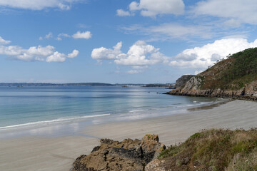 Obraz premium À marée basse, la plage de Trez Bihan révèle une vaste étendue de sable fin, entourée de rochers et falaises, sous un ciel bleu. Un coin paisible sur la presqu'île de Crozon en Bretagne.