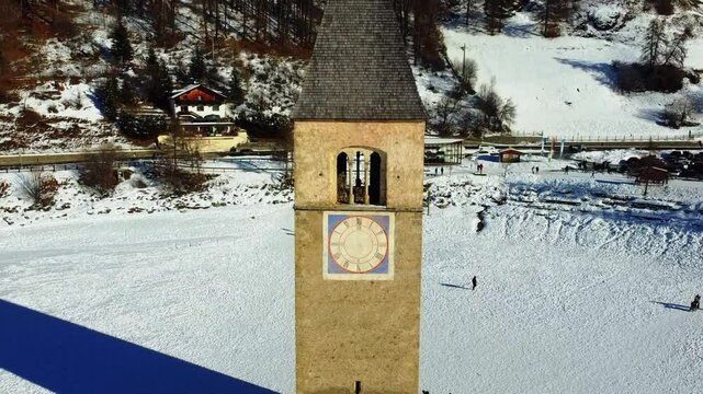 Winter on Lake Resia and magnificent isolated bell tower of the old village of Curon. Val Venosta
