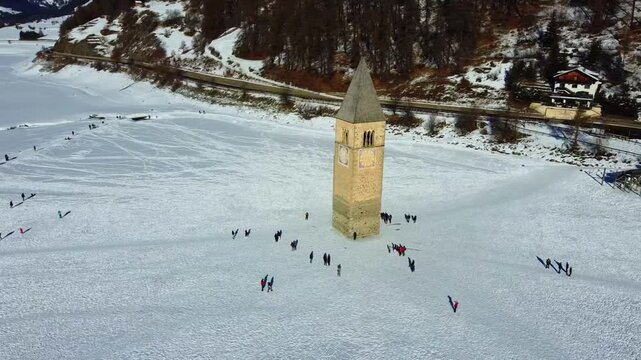 Winter on Lake Resia and magnificent isolated bell tower of the old village of Curon. Val Venosta