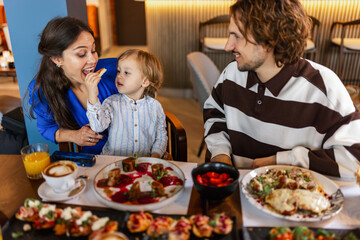 Family of three eating in a restaurant delicious food. Food and drink concept.