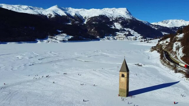 Winter on Lake Resia and magnificent isolated bell tower of the old village of Curon. Val Venosta