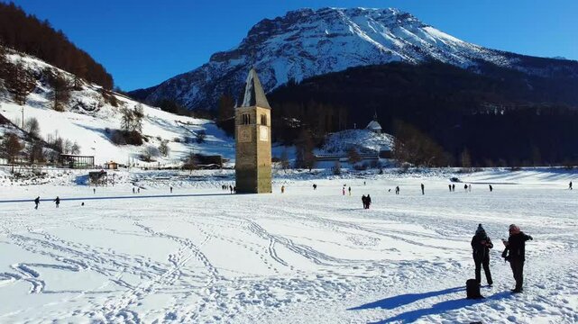 Winter on Lake Resia and magnificent isolated bell tower of the old village of Curon. Val Venosta