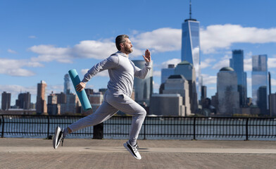 Man sportsman running for exercise in active wear. Sportsman jogger running. Sport runner in Manhattan. The sportsman running at view to New York. Banner