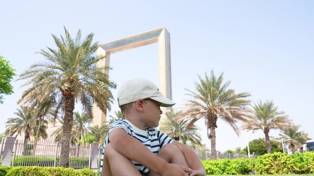 Dubai, Arab Emirates . Angry child sitting on golden frame background dubai