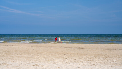 Obraz premium Cute children standing on beach and looking at sea. Boy and girl are enjoying vacation at sea. Family vacation. Vacation with children on the Baltic Sea. Germany