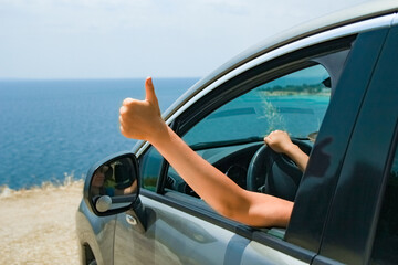 Naklejka premium A happy girl from car at sea greece background
