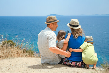 A happy family taking a selfie by the sea on a trip