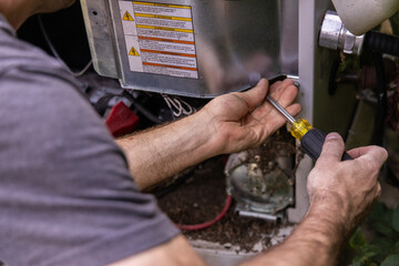 Hvac technician is working on the electrical components of a residential air conditioner unit. Selective focus