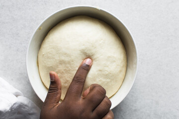 Checking if dough is proofed using a finger, process of making bread