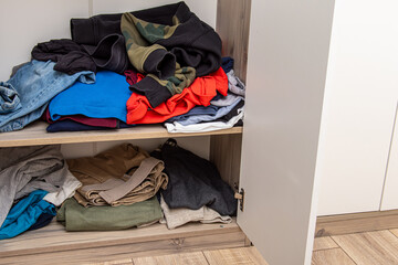 Messy closet. Chaos in the wardrobe. Sloppily folded clothes