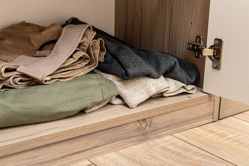 Neatly folded clothes on shelf in the closet. Organizing the order in closet