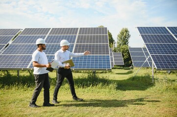 Two engineers or businessmen on the background of solar panels. Renewable energy. Green energy © Serhii
