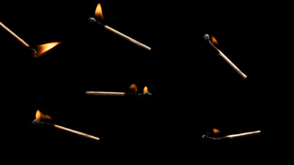 Lit falling match on a black background.