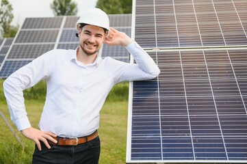 Portrait young technician or manager wearing formal cloths standing with solar panel. renewable energy