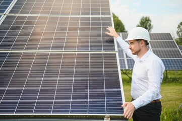 Young architect standing by solar panels