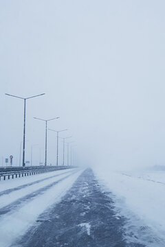 Empty frozen road in winter,
snow blizzard on the highway road, snowstorm on the road