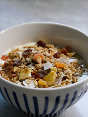 Breakfast bowl with yoghurt and muesli in it. A spoon in  it. Breakfast food. home made.