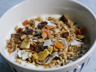 Breakfast bowl with yoghurt and muesli in it. A spoon in  it. Breakfast food. home made.