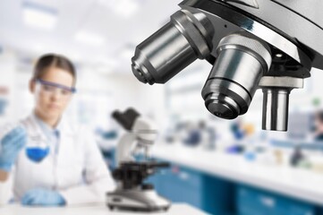 Double exposure of microscope and scientist using equipment .
