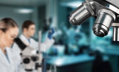 Double exposure of microscope and scientist using equipment .