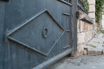 Elegant Blue Gate with Intricate Design in Quaint Stone Pathway