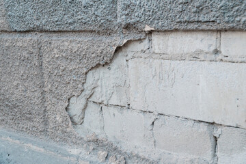 Crumbling Texture of an Aged Concrete Wall with Exposed Bricks and Layered Surfaces