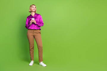 Full body portrait of nice young lady hold coffee look empty space wear shirt isolated on green color background