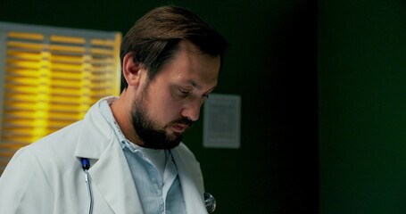 Serious young beard doctor in hospital.