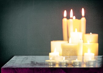 burning candles on dark background in room