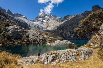 Woman Sits by Churup Lagoon with Turquoise Waters Beneath the Snow-Capped Peak of the Cordillera Blanca in the Huascaran National Park, in Ancash, Peru