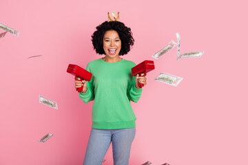 Photo portrait of rich girl queen in green sweatshirt and crown celebrating her income using money gun isolated on pink color background