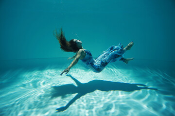 Woman in blue dress in zero gravity underwater